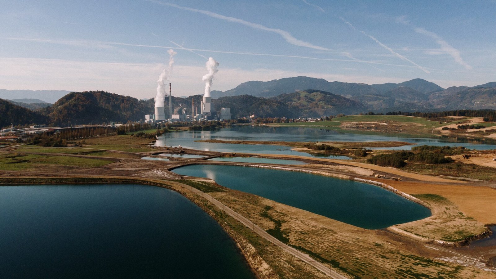 An aerial shot of a landscape surrounded by mountains and lakes with industrial disaster
